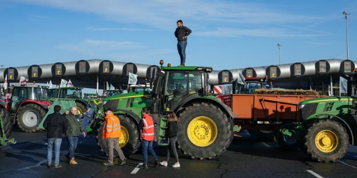 Διαμαρτυρόμενοι αγρότες αποκλείουν με τρακτέρ την εθνική οδό νοτιοδυτικά του Παρισιού, στις 26 Ιανουαρίου 2024, στο πλαίσιο μιας πανεθνικής διαμαρτυρίας που προκήρυξαν διάφορες ενώσεις αγροτών για τις αμοιβές, τη φορολογία και τους κανονισμούς. [Dimitar Dilkoff/AFP]