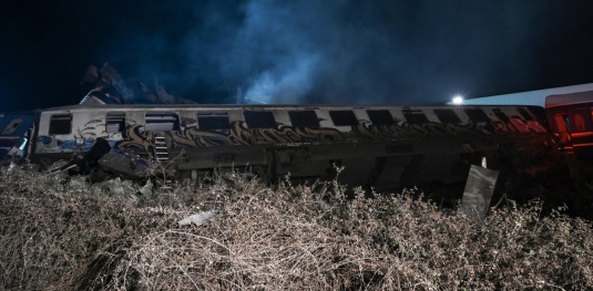 Εκτροχιασμένα βαγόνια κείτονται στο πλάι μετά από το σιδηροδρομικό δυστύχημα στην Κοιλάδα των Τεμπών, την 1η Μαρτίου 2023. [Sakis MITROLIDIS / AFP]