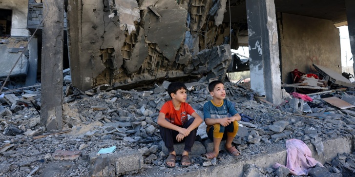 Παιδιά κάθονται ανάμεσα στα ερείπια ενός κτιρίου μετά από ισραηλινό χτύπημα στη Ράφα στη νότια Λωρίδα της Γάζας, στις 10 Νοεμβρίου 2023. [Mohammed ABED/AFP]