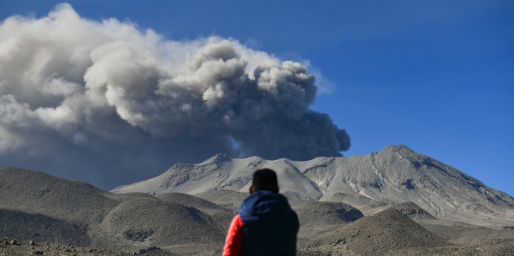 Ένας άνδρας παρακολουθεί μια στοίβα καπνού και τέφρας να υψώνεται από τον κρατήρα του ηφαιστείου Ουμπίνας στο Περού, στις 5 Ιουλίου 2023. [ Diego Ramos / AFP]