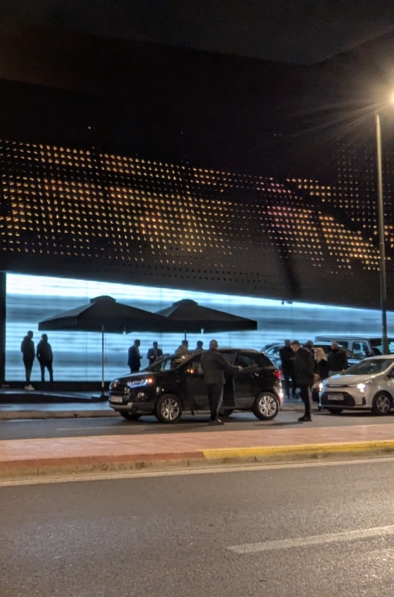 Ο παρκαδόρος ανοίγει την πόρτα της οδηγού πριν μπει για να το παρκάρει μέσα στο πάρκο
