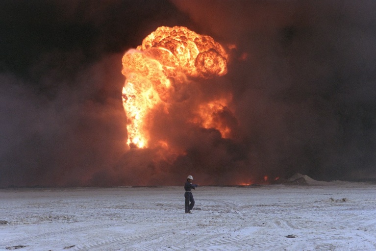 Ένας πυροσβέστης περπατά μπροστά από μια φλεγόμενη πετρελαιοπηγή, στις 28 Οκτωβρίου 1991 στο πετρελαϊκό πεδίο Rawdatayn στο Κουβέιτ. [MICHAEL ADLER/AFP]