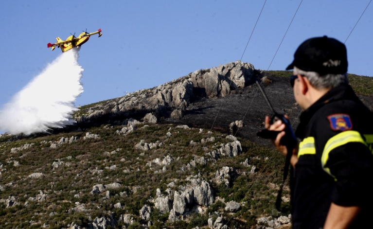 Πυροσβέστης επικοινωνεί με ασύρματο την ώρα που Καναντέρ επιχειρεί στη φωτιά στα Δερβενάκια τον Αύγουστο του 2018. [Βασίλης Παπαδόπουλος/Eurokinissi]
