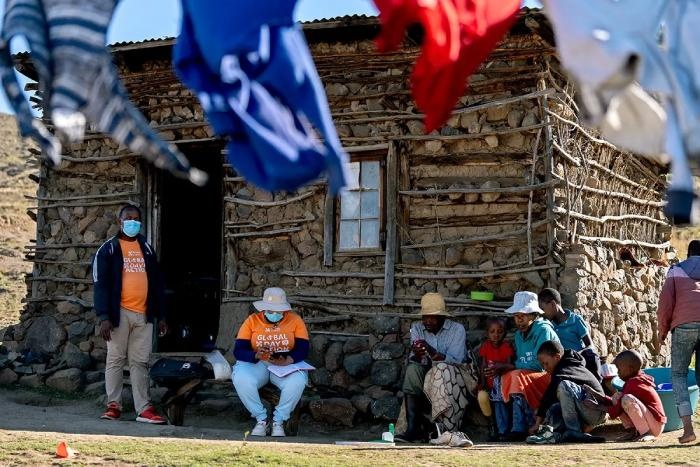 PIH Lesotho TB Screeners Ts'eliso Tobaka (left) and 'Maposholi Posholi (center) visit a family in Nkau, a remote region of the mountainous country, on April 20, 2024. Photo by Nishant Chandrasekar / PIH