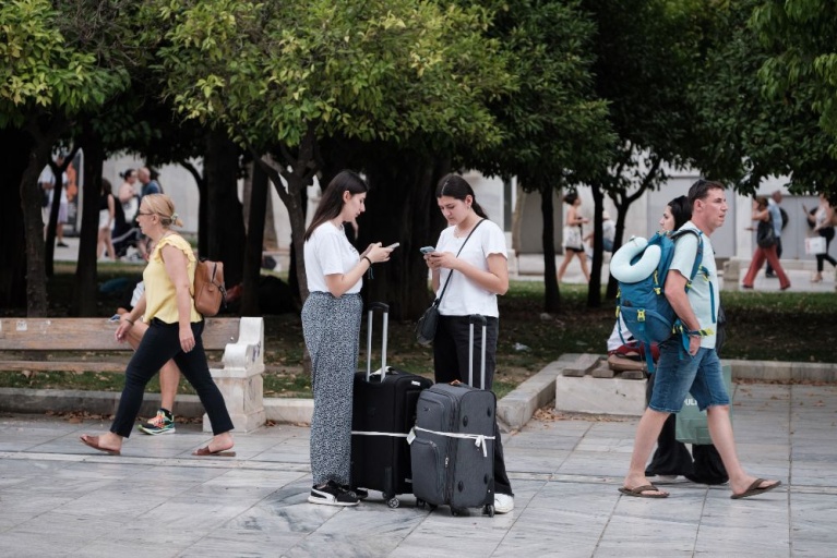 Τουρίστες μεταφέρουν βαλίτσες στην πλατεία Συντάγματος στην Αθήνα, Ελλάδα, στις 3 Ιουλίου 2024. [Νικόλας Κοκόβλης/NurPhoto]