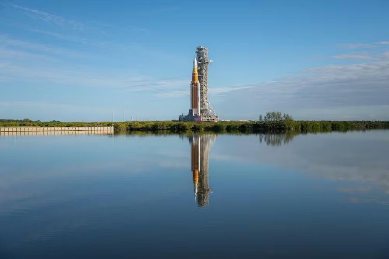 Ο πύραυλος SLS της αποστολής Artemis II και το διαστημικό σκάφος Orion κατά τη μεταφορά τους από το κτίριο συναρμολόγησης οχημάτων προς το Συγκρότημα Εκτόξευσης 39B στο Διαστημικό Κέντρο Κένεντι, στις 17 Ιανουαρίου 2026. [NASA/John Kraus]