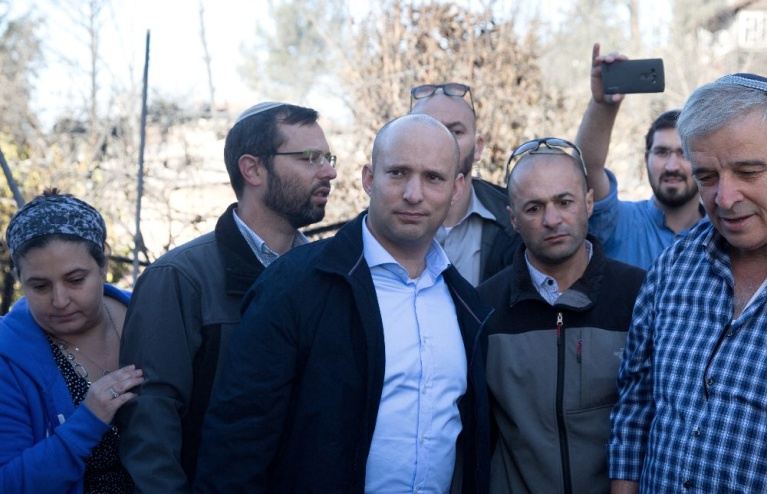 Ο Ισραηλινός υπουργός Παιδείας Ναφτάλι Μπένετ (στο κέντρο) επιθεωρεί τα καμένα σπίτια στον οικισμό Χαλαμίς, γνωστό και ως Νεβέ Τζουφ, βορειοδυτικά της Ραμάλα, κοντά στο χωριό Νάμπι Σαλέχ στην κατεχόμενη Δυτική Όχθη, στις 27 Νοεμβρίου 2016, μετά την πυρκαγιά που προκάλεσε ζημιές ή ολική καταστροφή σε 45 κατοικίες. [MENAHEM KAHANA / διάφορες πηγές / AFP]
