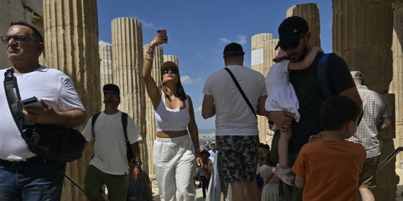 Τουρίστες περπατούν μέσα από τα Προπύλαια καθώς επισκέπτονται τον αρχαιολογικό χώρο της Ακρόπολης, στις 14 Ιουνίου 2023. [Louisa Gouliamaki/AFP]