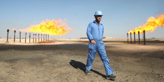 Ένας μηχανικός περπατά μπροστά από τις καμινάδες στις πετρελαιοπηγές Μπαρτζισίγια, νοτιοδυτικά της Βασόρας, 550 χλμ. από τη Βαγδάτη, στις 3 Φεβρουαρίου 2009. [ESSAM -AL-SUDANI/AFP]