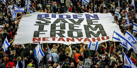 Διαδηλωτές καλούν τον πρόεδρο των ΗΠΑ να πιέσει την ισραηλινή κυβέρνηση να αναλάβει δράση για την επιστροφή των ομήρων που κρατούνται αιχμάλωτοι από Παλαιστίνιους μαχητές στη Λωρίδα της Γάζας, κατά τη διάρκεια αντικυβερνητικής διαδήλωσης στο Τελ Αβίβ, στις 13 Απριλίου 2024. [Jack Guez/AFP]