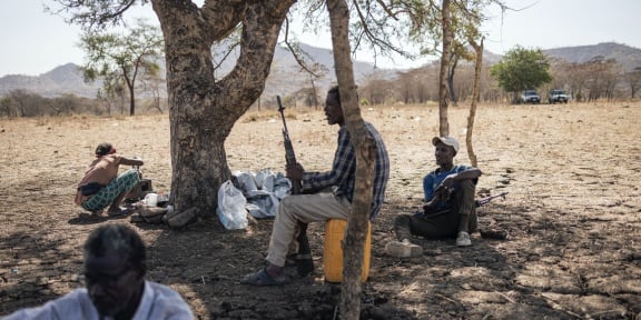 Δύο μέλη μιας τοπικής πολιτοφυλακής επιφορτισμένης με την ασφάλεια του καταυλισμού κάθονται στα περίχωρα του νεοσύστατου προσφυγικού καταυλισμού Αγουλάλα, κοντά στο Μαγκανάν, 80 χιλιόμετρα από τα σύνορα με το Σουδάν στην περιοχή Αμχάρα της Αιθιοπίας, στις 28 Φεβρουαρίου 2024.