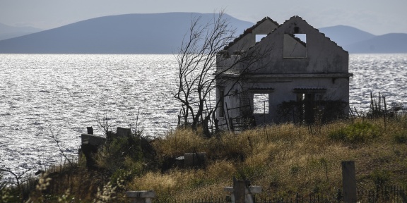 Ένα καμένο σπίτι στη θαλάσσια πλευρά του Μάτι, στις 21 Ιουλίου 2019, κατά τη διάρκεια τελετής μνήμης στη μνήμη των θυμάτων της πυρκαγιάς του Ιουλίου 2018 που στοίχισε τη ζωή σε 102 ανθρώπους. [Aris Messinis/AFP]