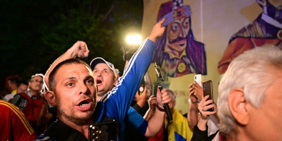 Υποστηρικτές του ηγέτη του εθνικιστικού κόμματος «Συμμαχία για την Ένωση των Ρουμάνων» AUR Τζορτζ Σιμιόν αντιδρούν μετά την ανακοίνωση των αποτελεσμάτων του exit poll κατά τη διάρκεια του πρώτου γύρου των προεδρικών εκλογών στο Βουκουρέστι στις 4 Μαΐου 2025.