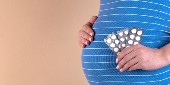 pregnant woman holding pills