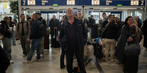Οι επιβάτες ελέγχουν τις οθόνες για πληροφορίες πτήσεων, καθώς η κυκλοφορία καθυστερεί λόγω τεχνικών προβλημάτων, στην αίθουσα αναχωρήσεων του Διεθνούς Αεροδρομίου Ελευθέριος Βενιζέλος της Αθήνας, στις 4 Ιανουαρίου 2025. [ANGELOS TZORTZINIS / AFP]
